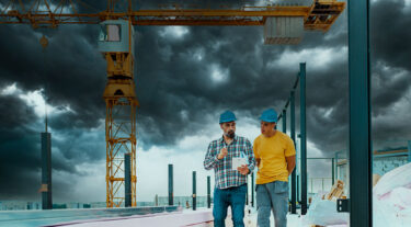 Two construction workers utilizing an AEM severe weather monitoring system.