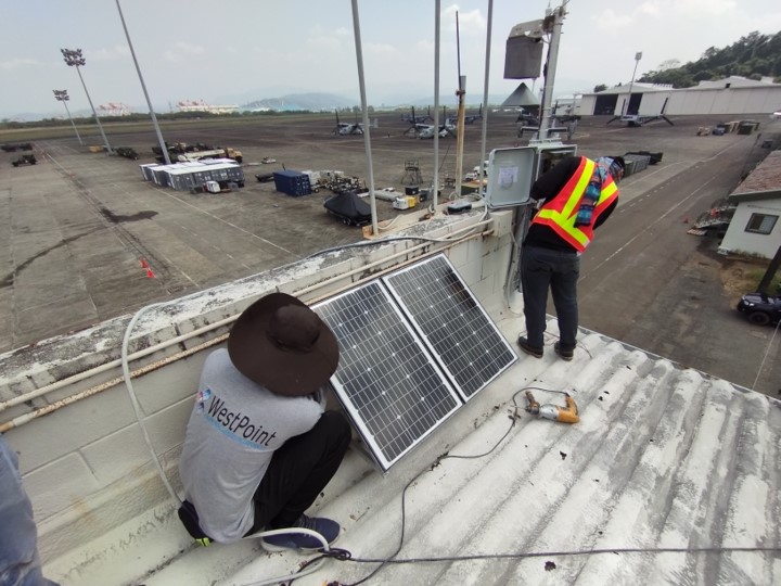 workers installing lightning siren and strobe light